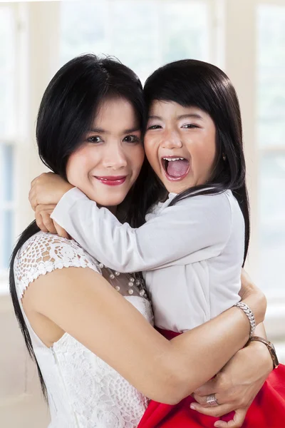 Chica alegre abraza a su madre en casa — Foto de Stock