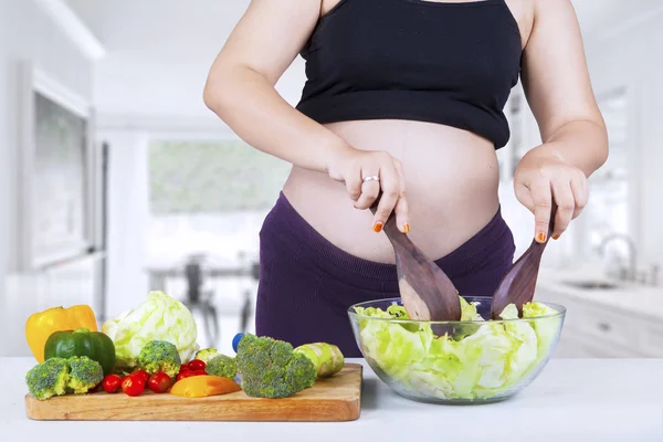 Madre incinta che mescola l'insalata — Foto Stock