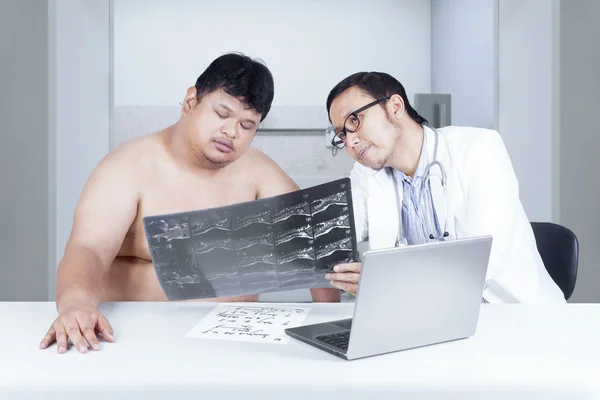 Doktor gösteren x-ışını kilolu kişi için — Stok fotoğraf