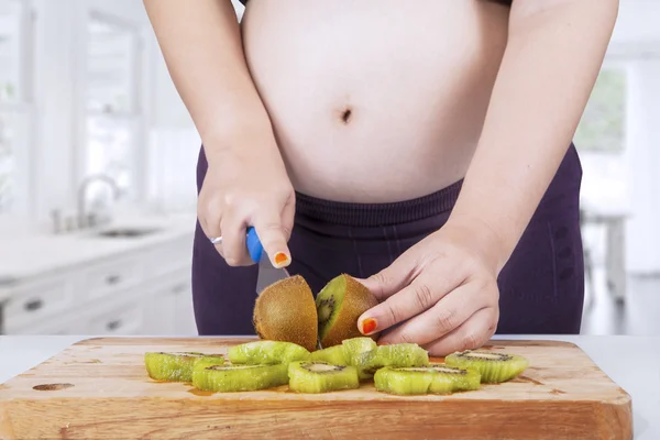 Υγιή έγκυος γυναίκα κόβει φρούτων — Φωτογραφία Αρχείου
