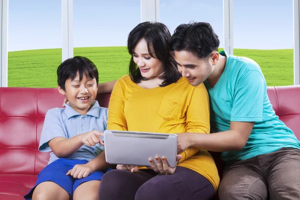Маленький мальчик и его семья с помощью планшета — стоковое фото