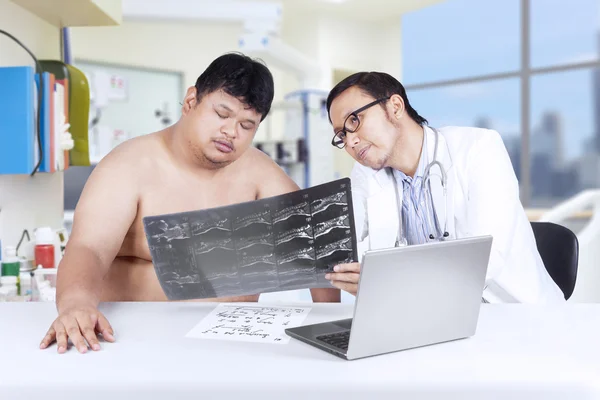 Physician showing x-ray to overweight person — Stock Photo, Image