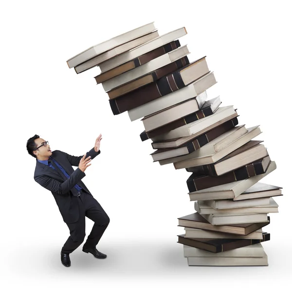 Businessman with falling books Royalty Free Stock Images