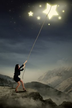Young businesswoman pulling stars clipart