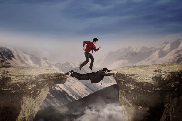 Coopération de deux hommes d'affaires à travers un fossé — Photo