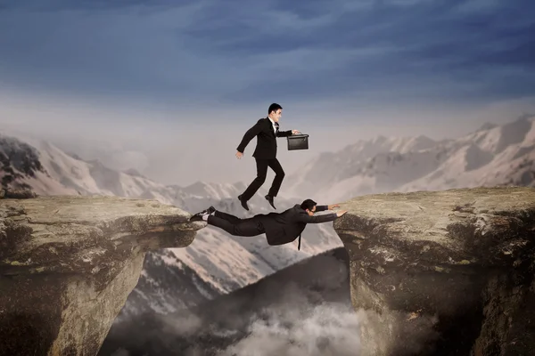 Courage of businessmen through the cliff — Stock Photo, Image