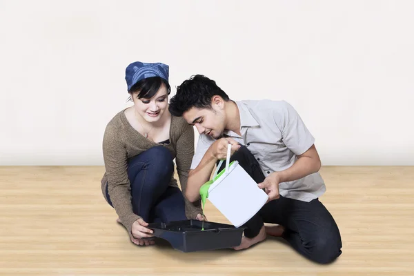 Couple pouring paint into tray — Stock Photo, Image