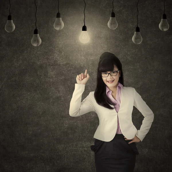 Empreendedor feminino escolhendo bulbo brilhante — Fotografia de Stock