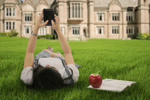 Fille couché sur l'herbe et textos avec téléphone portable — Photo