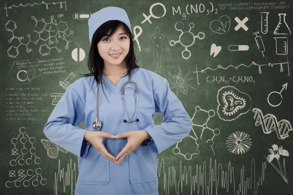 Cerrah öğrenci kalp sembol yapar — Stok fotoğraf