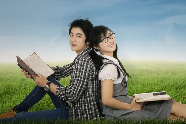 Два студента сидят на траве — стоковое фото