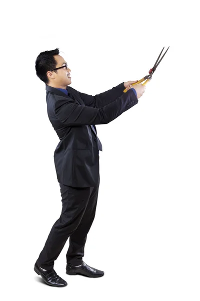 Businessman holding scissors to cut something — Stock Photo, Image