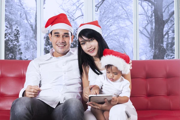 Familia con sombrero de Navidad en el sofá —  Fotos de Stock