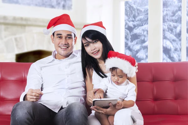 Familia feliz sentado en el sofá en el día de Navidad —  Fotos de Stock