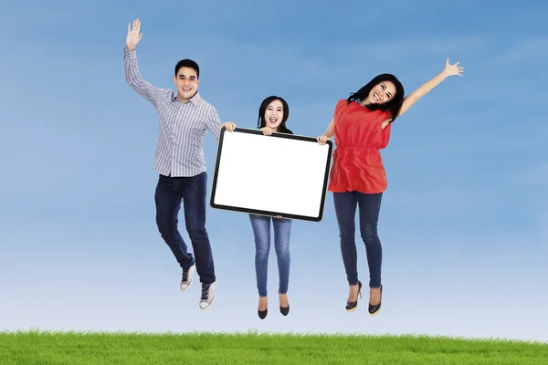 Happy people jumping with blank board — Stock Photo, Image