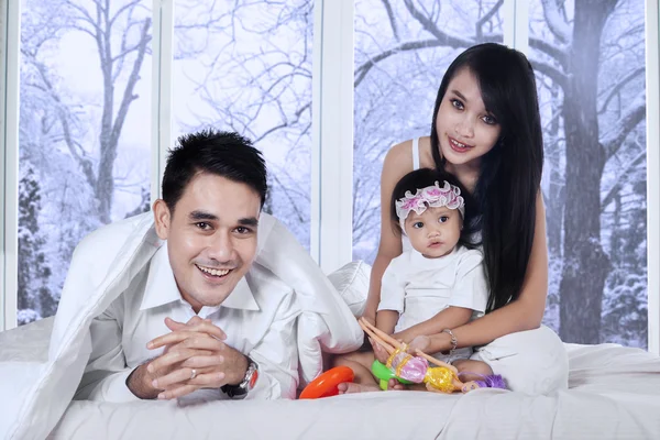 Família alegre na cama no dia de inverno — Fotografia de Stock