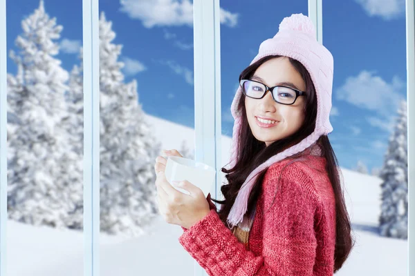 Sweet girl in winter clothes holding hot coffee — Stock Photo, Image