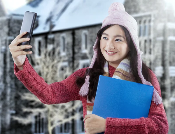 Söt student med vinterkläder tar bild — Stockfoto