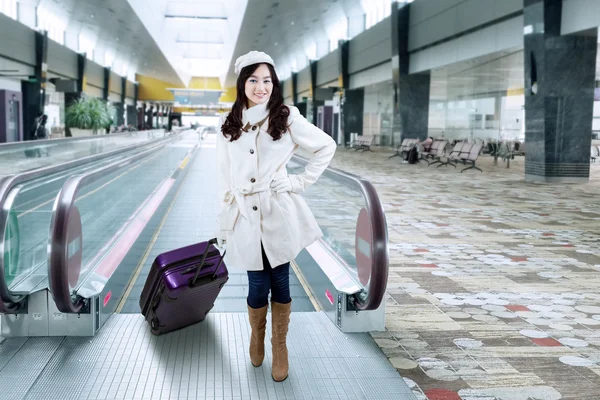 Chica en abrigo de invierno en el pasillo del aeropuerto —  Fotos de Stock