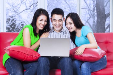 Kanepede dizüstü kullanan arkadaş grubu