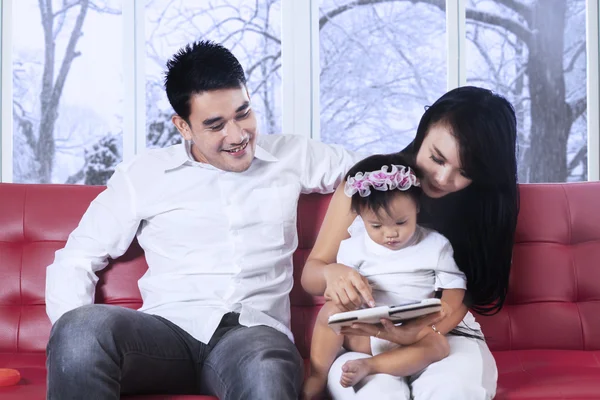 Familia asiática usando tableta en sofá — Foto de Stock