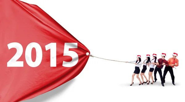 Equipo de negocios tirando de la bandera año nuevo — Foto de Stock