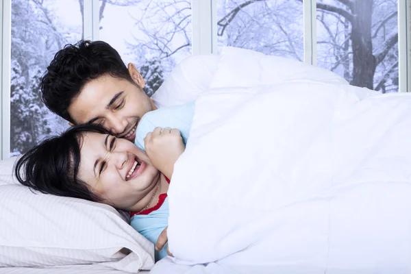 Couple blague sur le lit dans la journée d'hiver — Photo