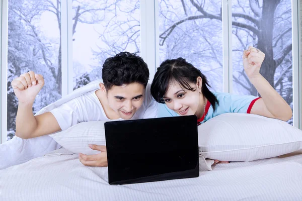 Koppel met laptop op bed in winterdag — Stockfoto