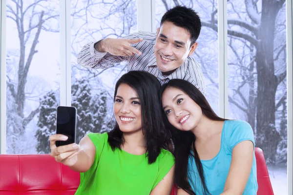 Tres amigos tomando fotos con teléfono celular — Foto de Stock