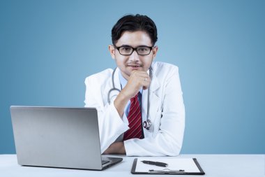 Kendine güvenen doktor kameraya bakıyor.