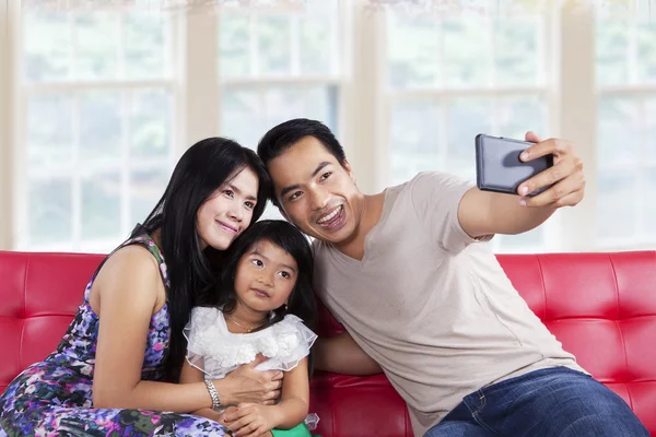 Famiglia in posa sulla fotocamera del telefono — Foto Stock