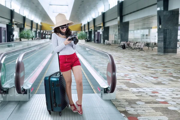 Vrouwelijke toeristische op roltrap op luchthaven — Stockfoto