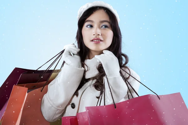 Mujer llevando bolsas de compras sobre fondo azul —  Fotos de Stock