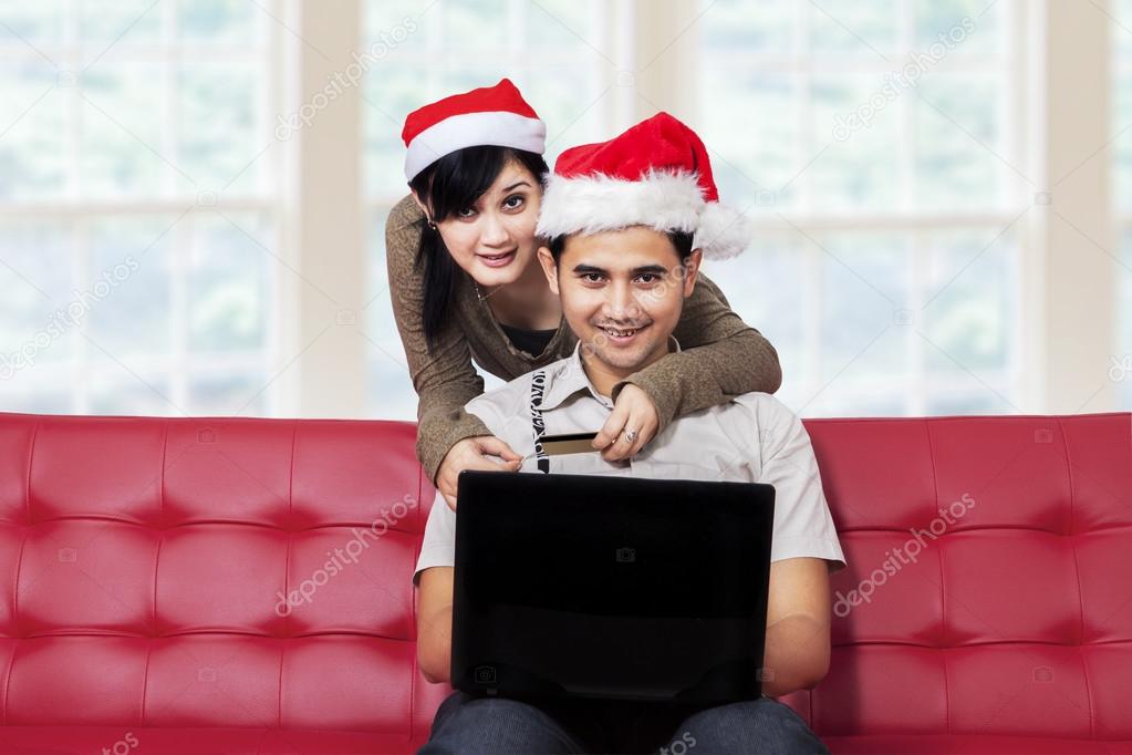 Couple smiling on camera while buy online