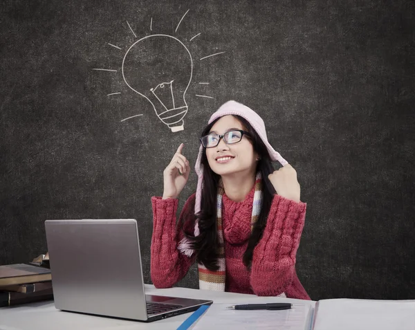 Vrouwelijke student in winterkleren in de klas — Stockfoto