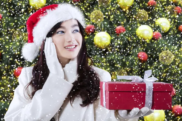 Chica con un regalo cerca del árbol de Navidad —  Fotos de Stock