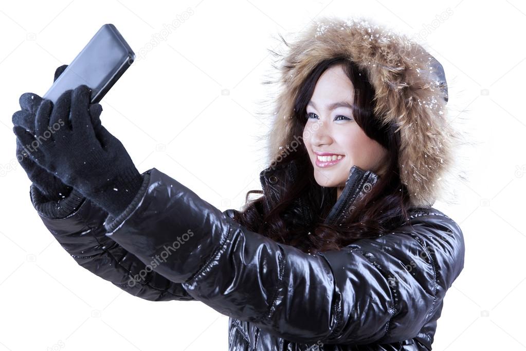 Girl in winter clothes taking self photo