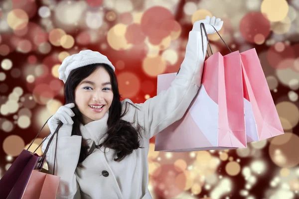 Girl in winter coat with shopping bags — Stock Photo, Image