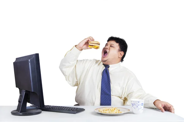 Hungry businessman eating fast food — Stock Photo, Image