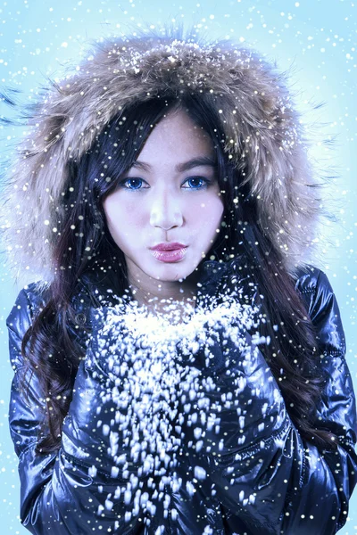 Menina hispânica atraente soprando neve — Fotografia de Stock