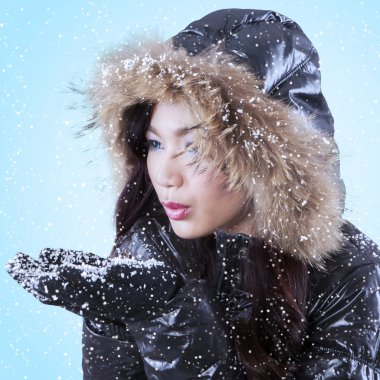 Genç Bayan kar üzerinde avuç içi üfleme