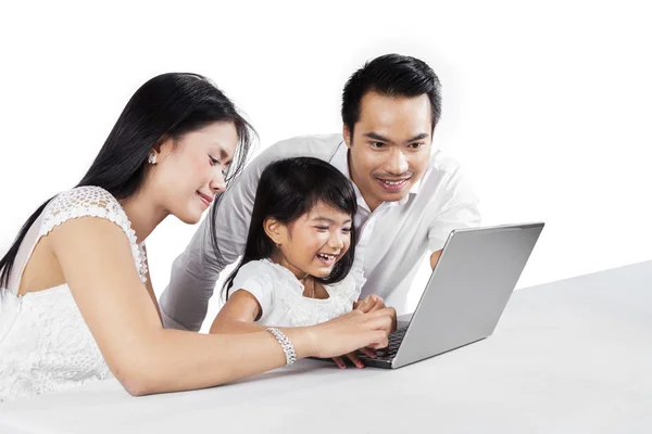 Веселая семья с ноутбуком в студии — стоковое фото