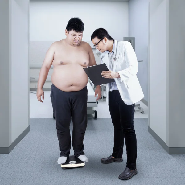 医師は患者の体重を記録します。 — ストック写真