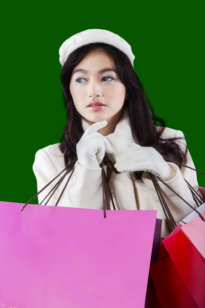 Girl holds shopping bags with green background — Stock Photo, Image