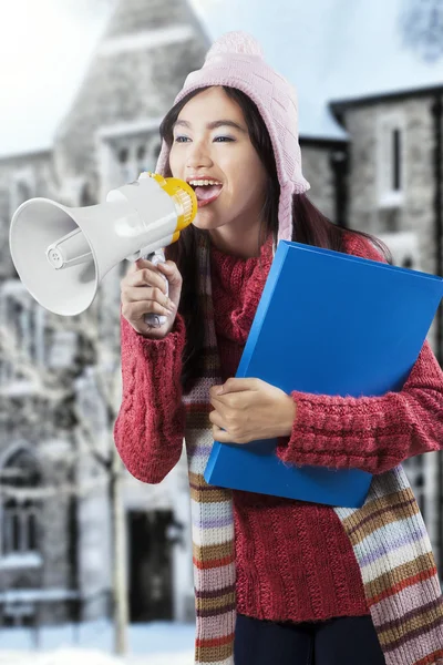 Estudante asiático em roupas de inverno gritando com megafone — Fotografia de Stock