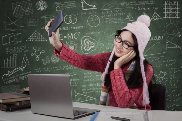 Attractive schoolgirl taking picture in class — Stock Photo, Image