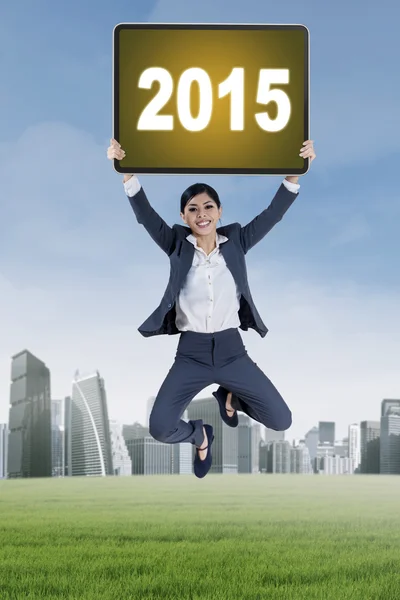Businesswoman jumps with number 2015 — Stock Photo, Image