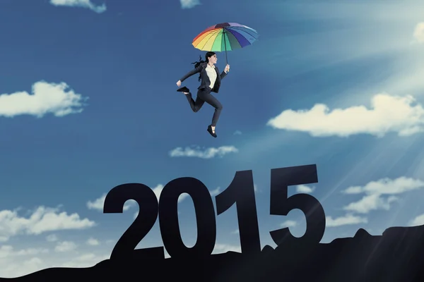 Empreendedor com guarda-chuva acima do número 2015 — Fotografia de Stock