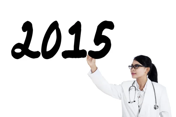 Femme médecin écrit numéro 2015 sur tableau blanc — Photo