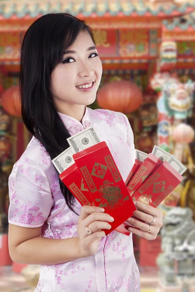 Flickan har dollar kontant i kuvertet vid templet — Stockfoto